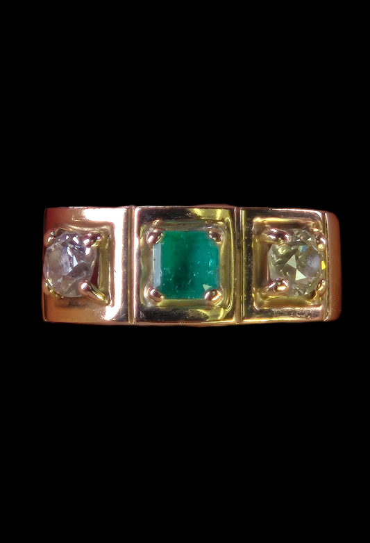 Studio photo of The Empress ring, featuring a square step-cut emerald flanked by two vintage diamonds in an 18K yellow gold setting.